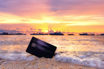 Credit card on the tropical beach in Pattaya at sunset,travel and holiday concept.