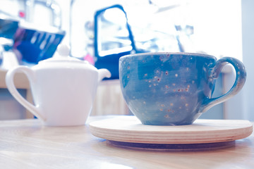 Blue Cup with tea or coffee and teapot on the stand