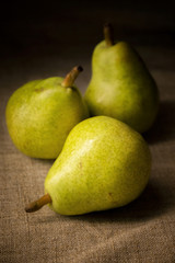 three rustic pears on a board with spices