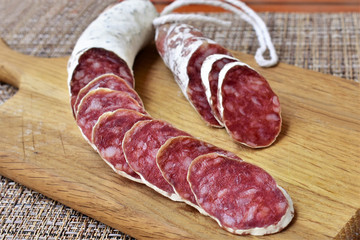 Dried sausage sliced on a wooden board, sausage texture.