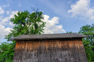 Old rustic wooden barn against blue sky. Close up.