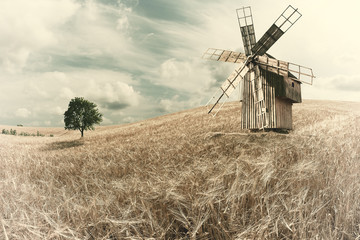 Fototapeta na wymiar Vintage Windmill on Wheat Field