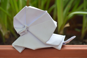 White origami snail on natural background