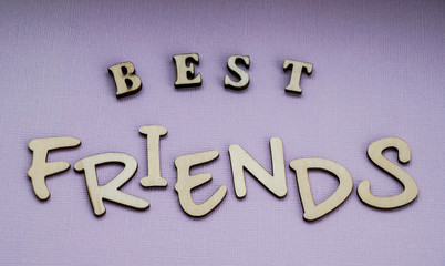 Message best friends of wooden blocks on a purple color background.
