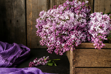 Bouquet of lilac flowers on an old box
