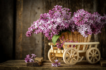 Fototapeta na wymiar Beautiful composition with bouquet of lilac in a wicker basket