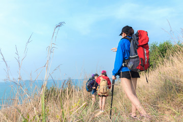 Fototapeta na wymiar Group asian young women of hikers walking with backpack on a mountain blue sky. Traveler going camping. Travel Concept.