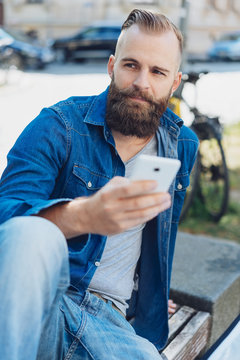 Young bearded man using mobile phone