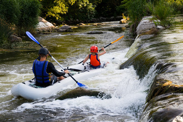 Two children of athletes in a boat on the river