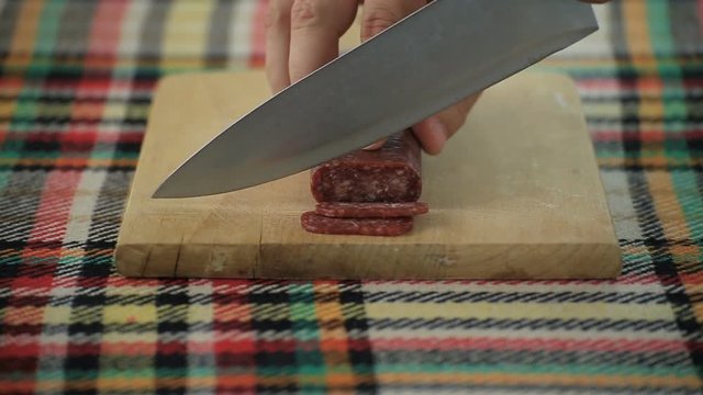 Cutting bulgarian flat sausage called lukanka