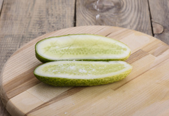 Salt falls on the halves of fresh cucumber