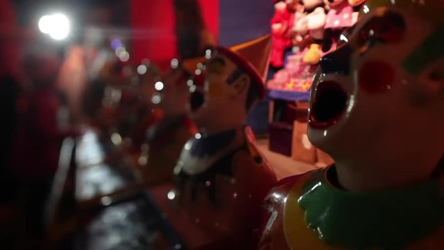 A shot of weird looking clowns used for games inside an amusement park.