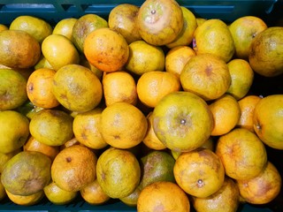 Top view of orange fruit as a background on market stand in Thailand. Fresh mandarin oranges group.