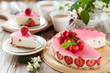 Slice of cheesecake with strawberry filling decorated with cherry jelly and fresh berries. Healthy organic summer dessert pie