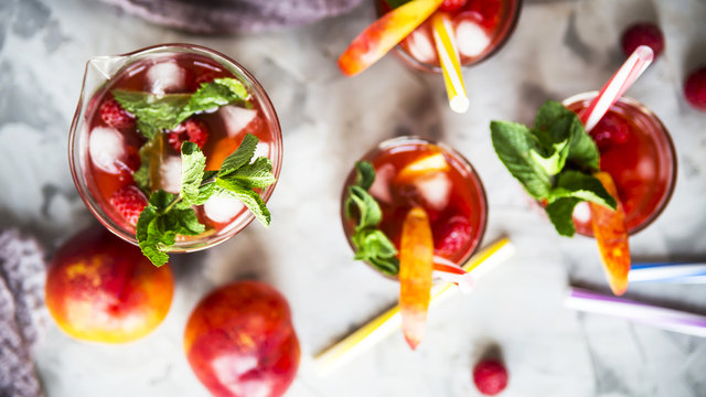 Light summer refreshing drink with fruits and berries - sangria. In glasses on a gray table. Top view, flat lay