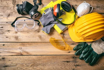 Poster Construction safety. Protective hard hat, headphones, gloves and glasses on wooden background, copy space, top view © Rawf8