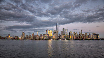 Fototapeta na wymiar New york city skyline daytime sun clouds blue golden hour
