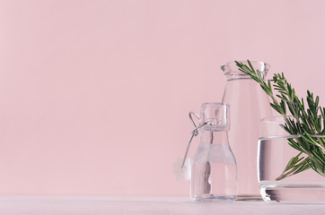 Modern simple art pink home decor with green plant in transparent vases on soft light white wood table, border.