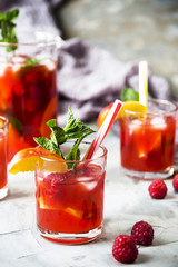 Light summer refreshing drink with fruits and berries - sangria. In glasses on a gray table