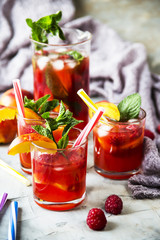 Light summer refreshing drink with fruits and berries - sangria. In glasses on a gray table