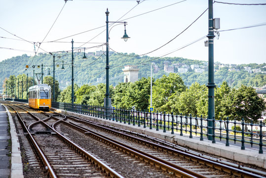 Railway with old yellow tram near the river during the morning light in Budapest city, Hungary