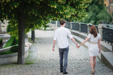 Obraz premium Young happy couple holding hands bridge in Prague