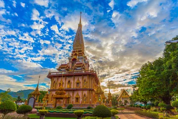 Papier Peint photo Temple Coucher de soleil nuageux au-dessus de la belle pagode dans le temple de Chalong Phuket Thaïlande