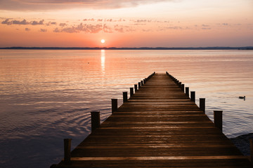 Holzsteg am See und romantischer Sonnenuntergang