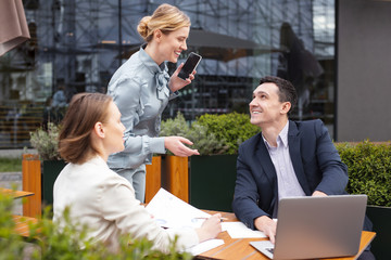 Calling husband. Blonde-haired stylish businesswoman feeling relieved while calling her husband being on coffee break