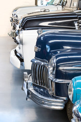 Classic cars on display in a warehouse.