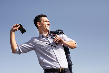 Angry businessman. Experienced stressed business man feeling very angry while throwing his smart phone away