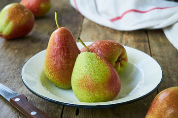 Ripe pears in a bowl on a wooden table