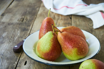 Ripe pears in a bowl on a wooden table