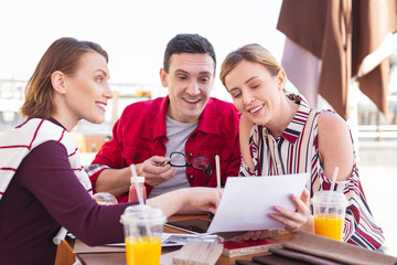 Modern freelancers. Three modern creative freelancers enjoying their break time sitting in the cafe outside