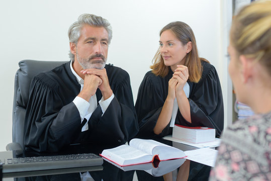 team of lawyers consulting client in office
