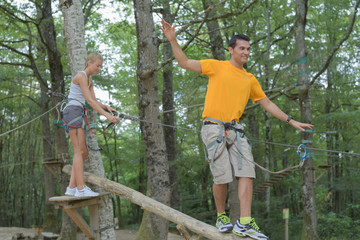 young man and woman having fun in the trees