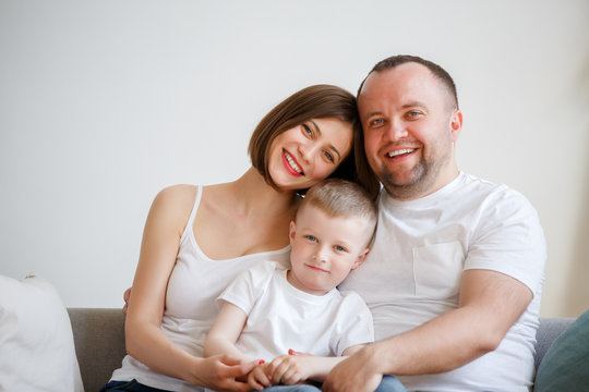 Picture of young parents with son sitting on sofa