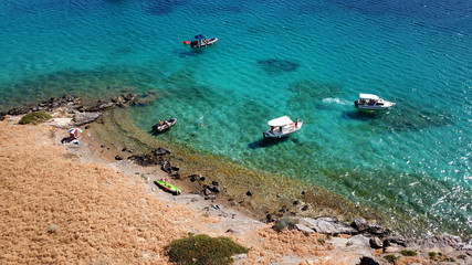 Obraz premium Aerial drone bird's eye view photo from boats docked in turquoise clear water rocky beach in island of Irakleia, Cyclades, Greece