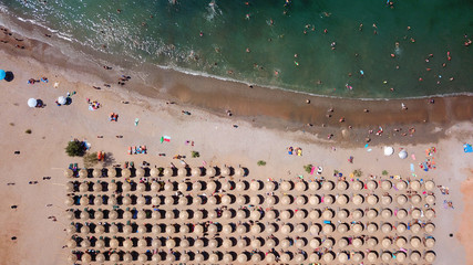 Aerial drone bird's eye view of iconic beach and small islet of Agios Nikolaos, Anavysos, Athens Riviera, Attica, Greece