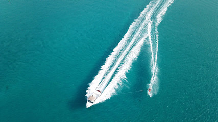 Aerial drone bird's eye view photo of man practicing water ski in tropical beach