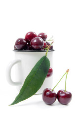 White cup with red sweet cherry isolated on a white background..