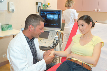 male doctor analyzing patient arm with tendon sonography - obrazy, fototapety, plakaty