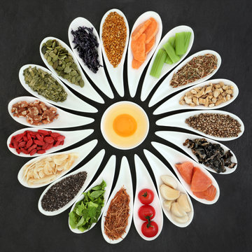 Food for the brain power and memory in china dishes on slate background. Super foods high in minerals, vitamins, antioxidants, omega 3 fatty acids and anthocyanins. Top view.