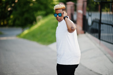 Stylish arabian muslim boy with originally hair and sunglasses posed on streets.