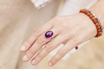 Female hand with Amethyst stone ring and rudraksha bracelet