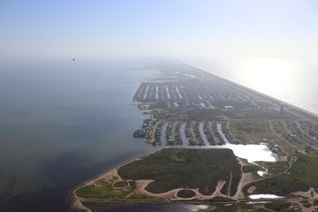 Aerial view of  the Texas Gulf Coast, Galveston Island, United States of America. Haze due to warm weather conditions. Two powered paragliders, paramotors, real estate and travel landscape panorama.