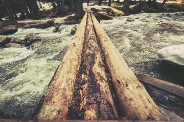 a bridge of logs across a mountain river