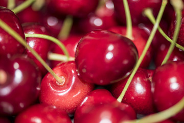 Dark, ripe and juicy cherries on a black plate