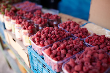 Raspberries on a farm market in the city. Fruits and vegetables at a farmers summer market.