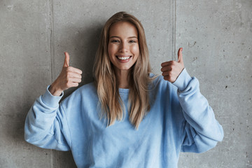 Happy pretty woman showing thumbs up gesture.